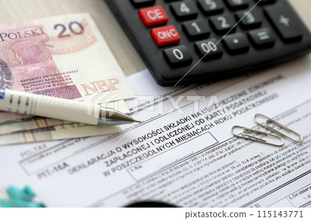 Declaration of amount of health insurance contributions paid and deducted from tax card in individual months of tax year, PIT-16A form on accountant table with pen and polish zloty money bills Declaration of amount of health insurance contributions paid and deducted from tax card in individual months of tax year, PIT-16A form on accountant table with pen and polish zloty money bills 115143771