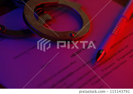 District Court Arrest Warrant court papers with handcuffs and blue pen on United States flag. Concept of permission to arrest suspect 115143791