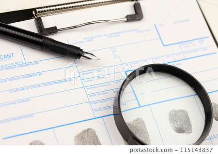 Fingerprints card police form on A4 tablet lies on office table with pen and magnifying glass close up 115143837