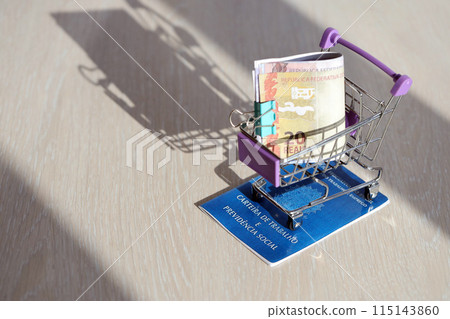 Brazilian work card and social security blue book and reais money bills in shopping cart close up 115143860