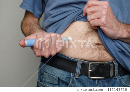 Man making Injection in her Stomach. Semaglutide or Insulin Injection Diabetes Drug Man making Injection in her Stomach. Semaglutide or Insulin Injection Diabetes Drug 115145716