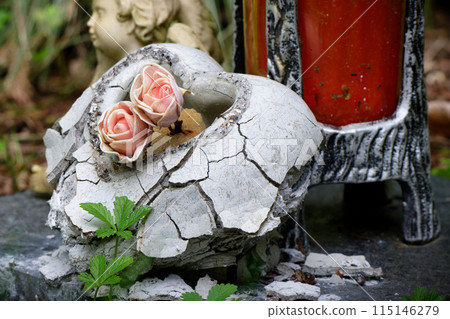stone heart with roses on a abandoned grave 115146279