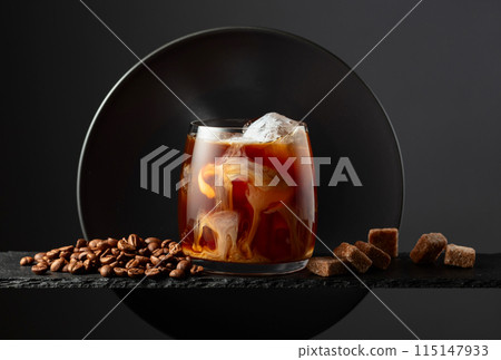 Iced coffee with cream on a black background. 115147933