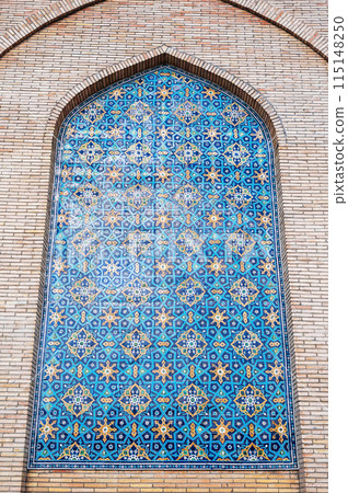 ancient ceramic tile with traditional Uzbek ornament Arabic Islamic pattern on wall of the medieval Muslim mosque Hazrati Imam in Uzbekistan 115148250