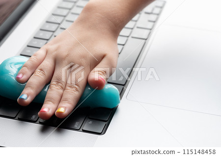 Sweeping away dust from computer keyboard Sweeping away dust from computer keyboard 115148458