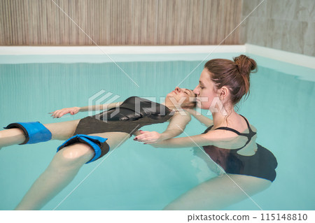 Two woman in pool. Watsu. Water rehabilitation massage. Aqua therapy exercise Two woman in pool. Watsu. Water rehabilitation massage. Aqua therapy exercise 115148810