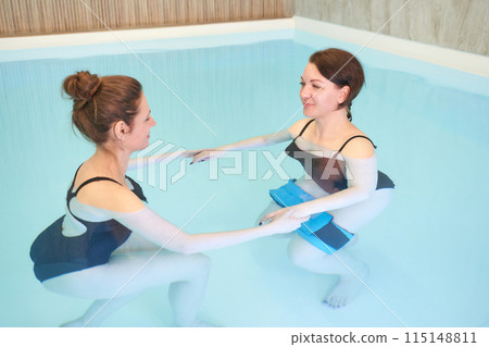 Two woman in pool. Watsu. Water rehabilitation massage. Aqua therapy exercise 115148811