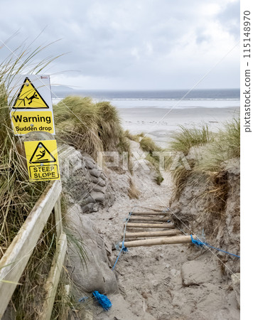 Signs warning of Sudden Drop and Steep Slope at Dooey beach by Lettermacaward in County Donegal - Ireland. Signs warning of Sudden Drop and Steep Slope at Dooey beach by Lettermacaward in County Donegal - Ireland. 115148970