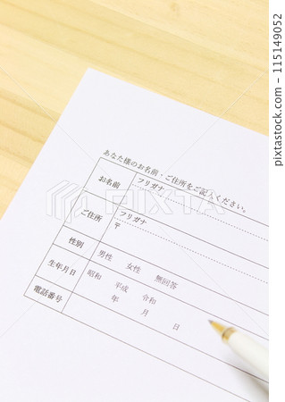 Image of filling out a document [Personal information, on a wooden desk, simple, up] 115149052