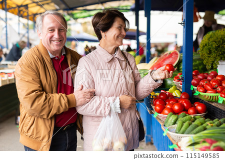 Elderly men and women buying tomatoes at an open market Elderly men and women buying tomatoes at an open market 115149585