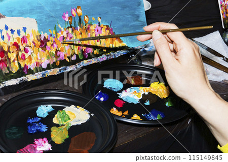 Person painting with blue brush on table with nails and accessories Person painting with blue brush on table with nails and accessories 115149845