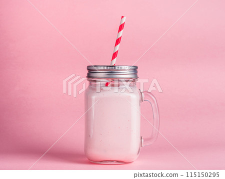 strawberry smoothie in mason jar glass on pink 115150295