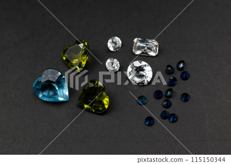 Small faceted gemstones on black background, heart shaped crystal gems 115150344