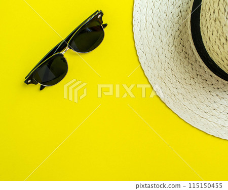 Flatlay, summer vacation. Straw hat and sunglasses on a yellow background. 115150455