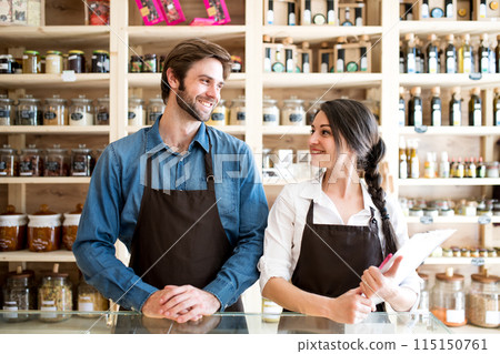 Two shop assistants in package-free store using reusable containers. Zero waste shops offering package-free bulk goods and sustainable alternatives. Two shop assistants in package-free store using reusable containers. Zero waste shops offering package-free bulk goods and sustainable alternatives. 115150761