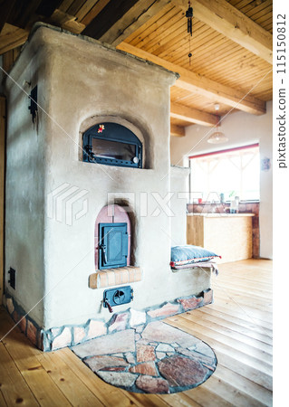 Handmade clay oven indoor. Interior of kitchen in vintage rustic style with wooden furniture in a cottage 115150812