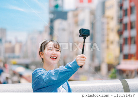 A young woman taking a selfie while sightseeing in Osaka 115151457