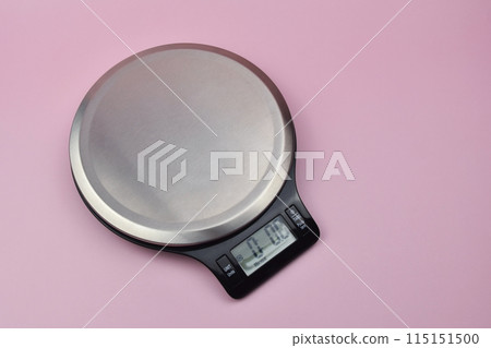 Digital kitchen scale on pink background 115151500