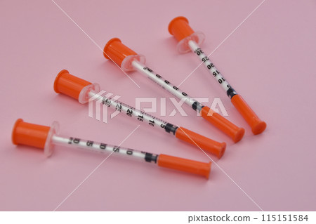 Plastic syringes for injection on a pink background close-up. A pink background featuring an insulin syringe, symbolizing diabetes management and the importance of healthcare 115151584