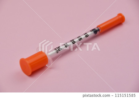 Medical syringe on a pink background. Close-up, selective focus. A pink background featuring an insulin syringe, symbolizing diabetes management and the importance of healthcare Medical syringe on a pink background. Close-up, selective focus. A pink background featuring an insulin syringe, symbolizing diabetes management and the importance of healthcare 115151585