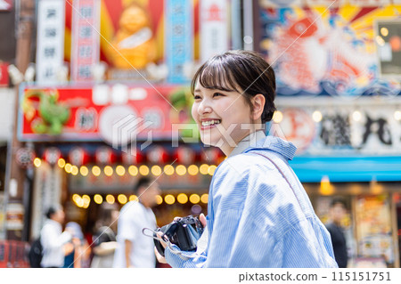 A camera girl taking pictures of the streets of Osaka 115151751