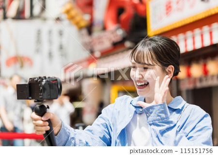 A young woman taking a selfie while sightseeing in Osaka 115151756