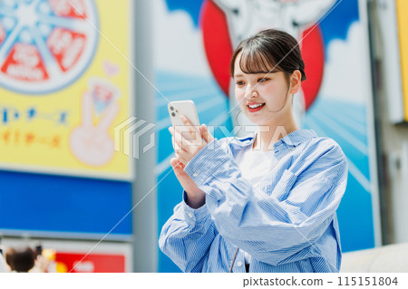 A young woman taking a selfie at Ebisubashi Bridge in Osaka 115151804