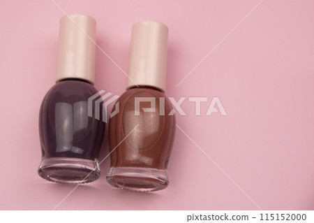 Nail polish small glass bottles on pink background, professional manicure concept 115152000