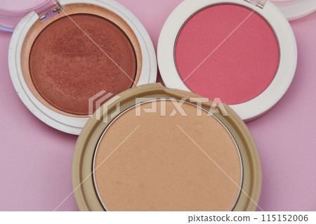 Coral blush, fuchsia eyeshadows and tan face powder on pink background, cosmetics and makeup Coral blush, fuchsia eyeshadows and tan face powder on pink background, cosmetics and makeup 115152006