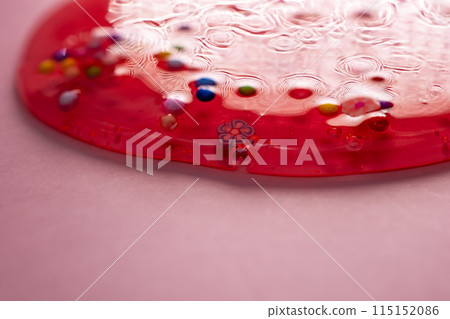 A vibrant and lively image captures a colorful, gel-textured skincare cream with effervescent bubbles, set against a backdrop adorned with decorative figurines A vibrant and lively image captures a colorful, gel-textured skincare cream with effervescent bubbles, set against a backdrop adorned with decorative figurines 115152086