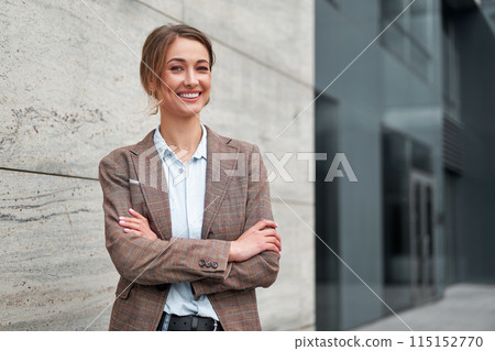 Smiling businesswoman standing arms crossed Smiling businesswoman standing arms crossed 115152770