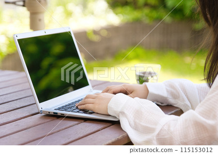 A young woman looking at a laptop on a terrace 115153012