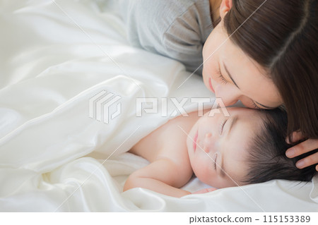 Baby sleeping next to mother Baby sleeping next to mother 115153389