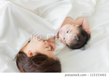 Baby sleeping next to mother 115153401