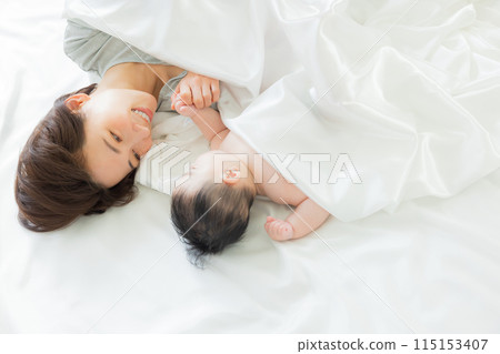 Baby sleeping next to mother 115153407