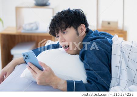 A man who overslept and is looking at the clock A man who overslept and is looking at the clock 115154222