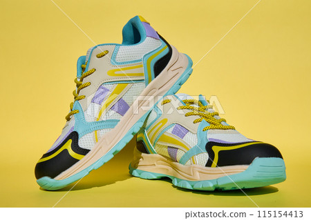 Fashionable Sneakers on yellow background. Creative banner with stylish shoes Fashionable Sneakers on yellow background. Creative banner with stylish shoes 115154413