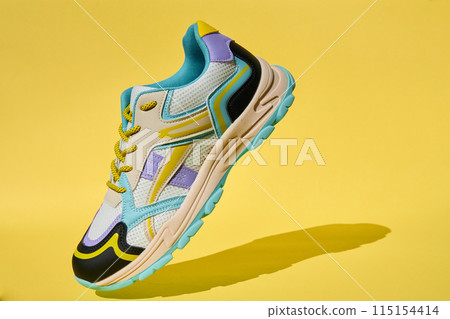 Colorful Sport Sneaker on Vibrant Yellow Background Colorful Sport Sneaker on Vibrant Yellow Background 115154414
