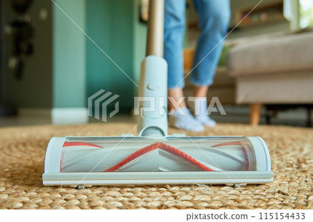 Close up of vacuum cleaner brush cleaning carpet on floor Close up of vacuum cleaner brush cleaning carpet on floor 115154433