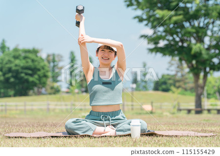 女性在公園裡用啞鈴鍛煉和訓練（肌肉和肌肉訓練） 115155429