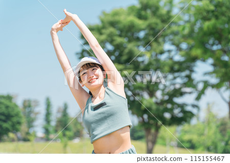 穿著運動服的年輕亞洲女性在公園裡伸展、熱身、深呼吸 115155467