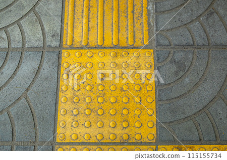 Yellow Braille Blocks on the Sidewalk, Providing a Pathway for Visually Impaired Individuals 115155734