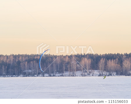 Kite surfer ride on snowboard. Snowkiting in the snow on frozen lake. Kite surfer ride on snowboard. Snowkiting in the snow on frozen lake. 115156033