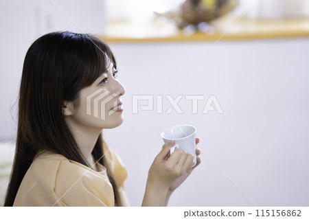 woman drinking coffee in the living room 115156862