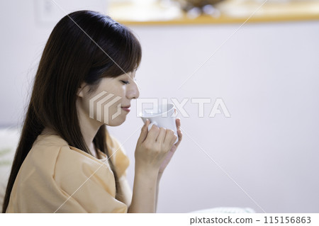 woman drinking coffee in the living room 115156863