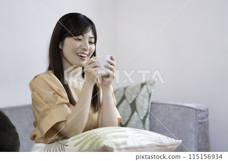 woman drinking coffee in the living room woman drinking coffee in the living room 115156934