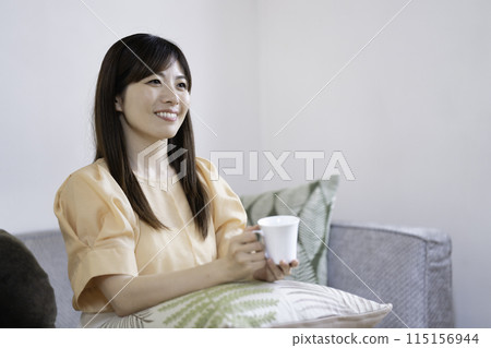 woman drinking coffee in the living room 115156944