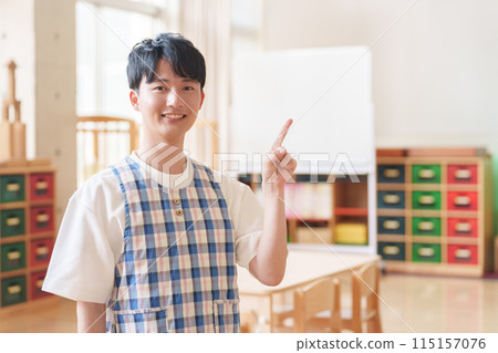 Male nursery teacher pointing at nursery school Male nursery teacher pointing at nursery school 115157076