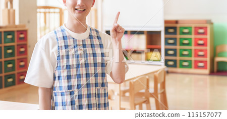 Male nursery teacher pointing at nursery school 115157077