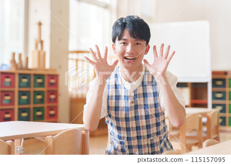 Male nursery teacher working at a nursery school 115157095